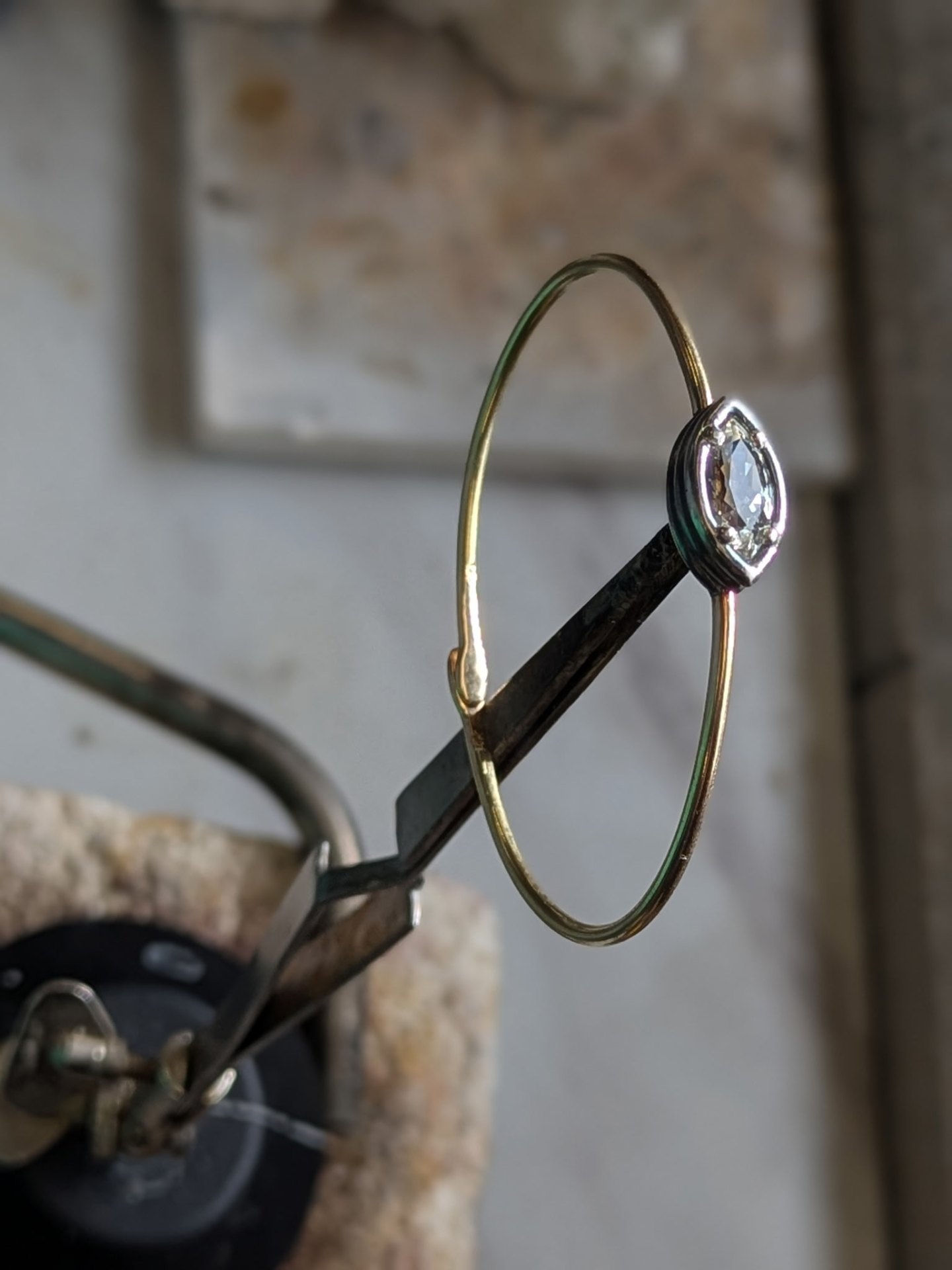 A hand-crafted gold ring resting on warm ivory linen